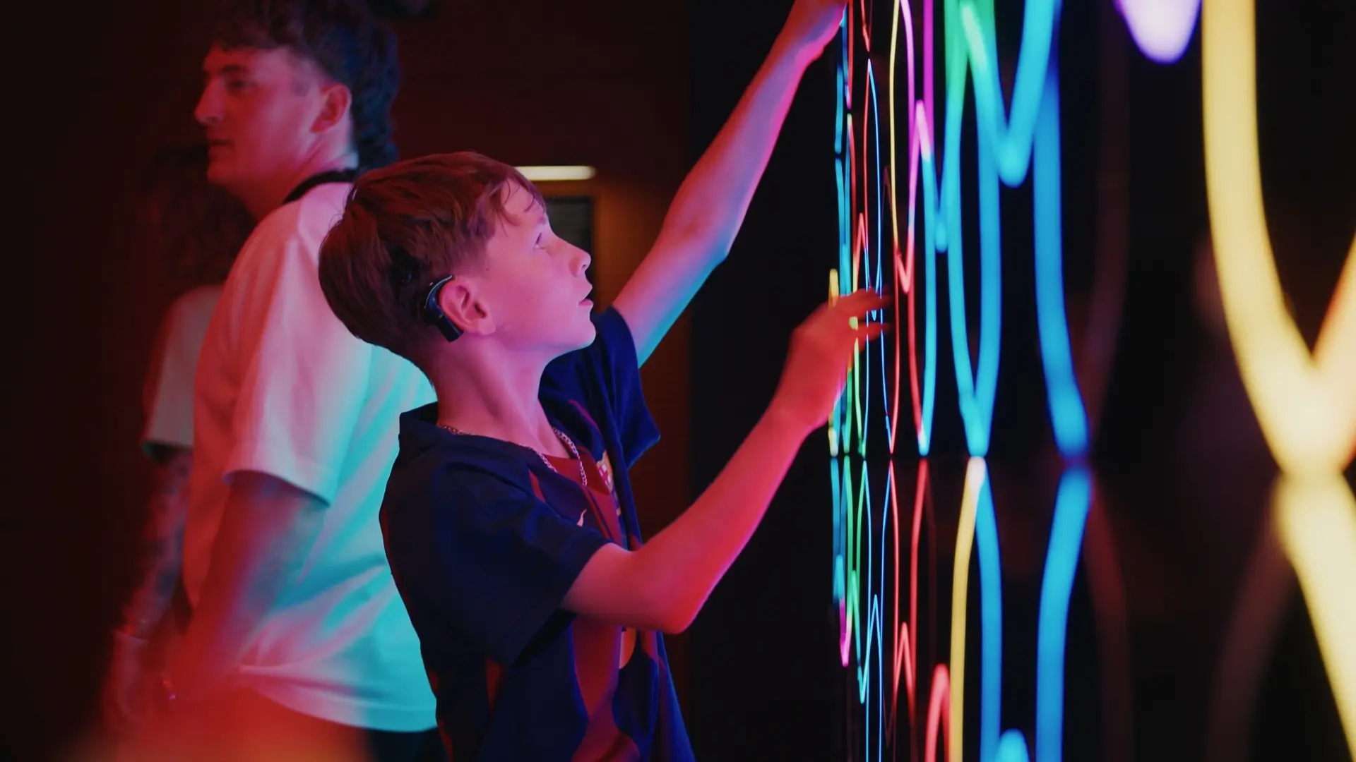 Guest pressing illuminated buttons on an interactive wall