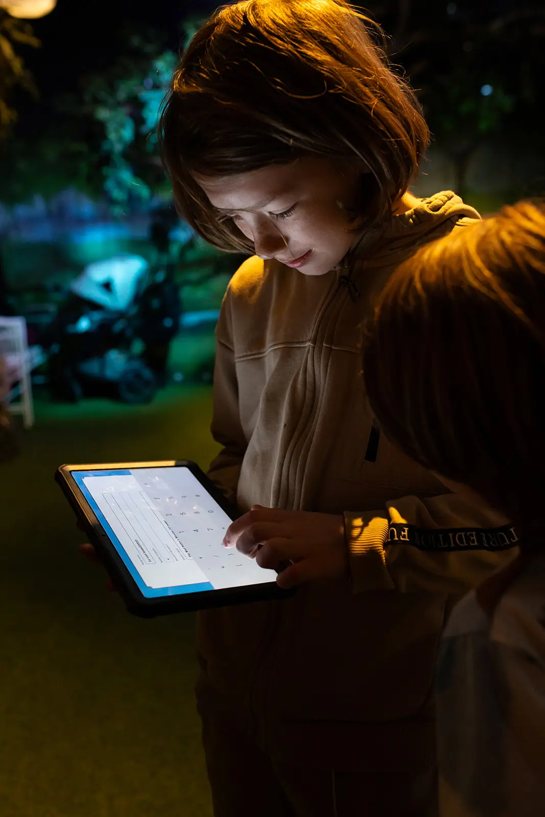 Children gathered around an interactive area solving puzzles in the environment